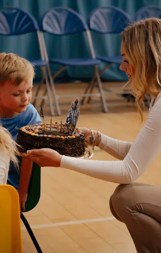 Mother presenting a birthday cake to her son